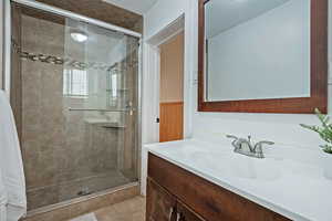 Full bath featuring a shower stall, tile patterned floors, and vanity