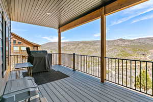 Deck with a mountain view and area for grilling