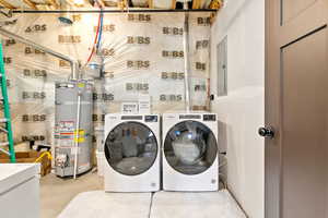 Laundry area featuring washer and dryer,  water heater, and electric panel
