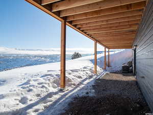 Snowy yard featuring central AC