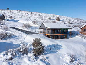 Snow covered house featuring a wooden deck