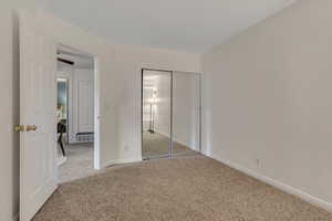 Unfurnished bedroom featuring carpet flooring, a closet, and baseboards