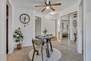 Dining area featuring ceiling fan, light carpet, and baseboards