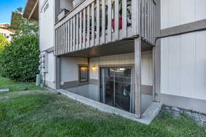 Back of property with a balcony and a lawn