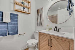 Full bathroom with vanity, toilet, and a shower