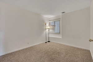 Carpeted empty room featuring baseboards