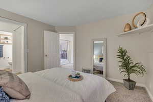 Bedroom with carpet, baseboards, and ensuite bathroom