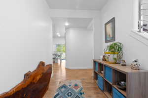 Hallway with light wood-style floors, baseboards, and recessed lighting
