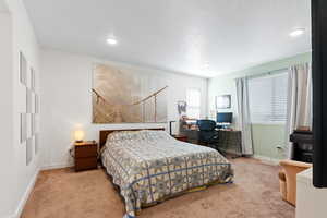 Carpeted bedroom featuring a textured ceiling, baseboards, and recessed lighting