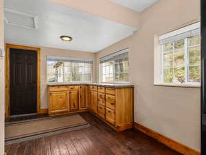 Kitchen with brown cabinetry, baseboards, and dark wood-style floors