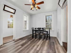 Dining room featuring baseboards, wood finished floors, and a wealth of natural light