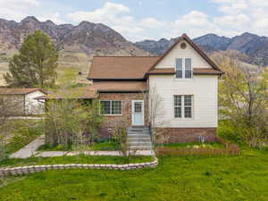 View of front of house with a front yard and a mountain view