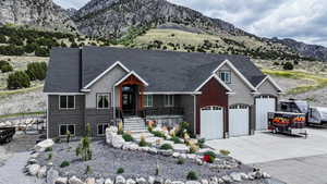 View of front of house with concrete driveway, a mountain view, a garage, and roof with shingles