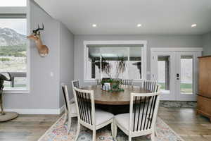 Dining room with healthy amount of natural light, wood finished floors, french doors, a mountain view, and recessed lighting