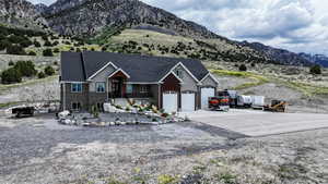View of front of house with concrete driveway, a mountain view, a garage, and brick siding
