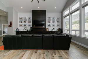 Living room featuring plenty of natural light, light wood-style floors, vaulted ceiling, and recessed lighting