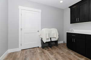 Laundry area with cabinet space, light wood-style floors, recessed lighting, and hookup for a washing machine