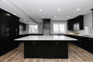 Kitchen featuring dark cabinets, a kitchen island, light countertops, and recessed lighting