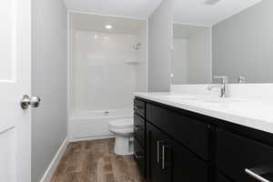 Bathroom featuring vanity, wood finished floors, and shower / bath combination