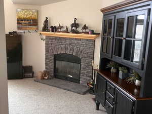 Living room featuring carpet flooring and a stone fireplace