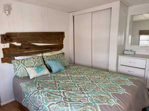 Bedroom with wood walls and a closet