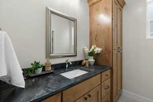 Bathroom with baseboards, vanity, and tile patterned flooring