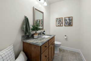 Bathroom with baseboards, toilet, and vanity