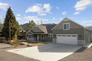 Craftsman-style home featuring board and batten siding, stone siding, and a mountain view