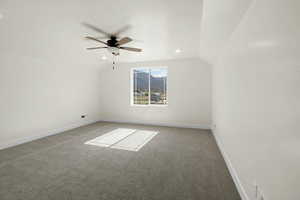 Additional living space with vaulted ceiling, baseboards, carpet, and ceiling fan