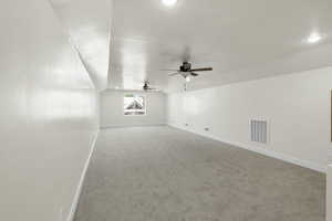 Bonus room with carpet, vaulted ceiling, visible vents, baseboards, and ceiling fan