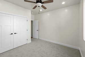 Unfurnished bedroom with recessed lighting, a closet, baseboards, light colored carpet, and ceiling fan