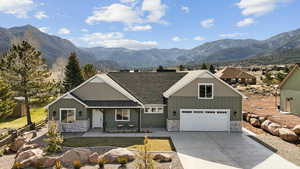 View of front facade with stone siding, board and batten siding, and a mountain view