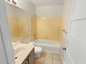 Full bath with vanity, toilet, tile patterned flooring, and bathing tub / shower combination