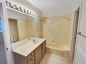 Bathroom featuring tile patterned flooring, vanity, and  shower combination