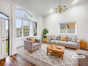 Living room featuring recessed lighting, vaulted ceiling, wood finished floors, baseboards, and a notable chandelier