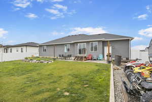 Rear view of house featuring fence, entry steps, a yard, a patio, and stucco siding
