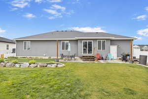 Rear view of house with fence, entry steps, and a patio