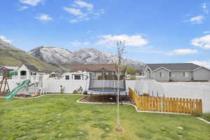 View of yard with a residential view, a trampoline, and a fenced backyard