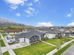 View of front of property featuring a residential view, an attached garage, concrete driveway, and fence