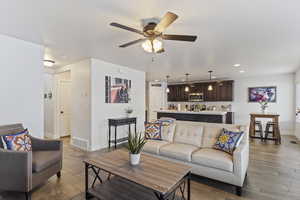 Living area featuring recessed lighting, wood tiled floor, visible vents, a ceiling fan, and baseboards