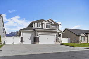 Craftsman inspired home featuring a gate, fence, concrete driveway, and board and batten siding