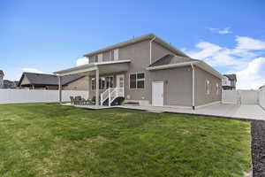 Back of property featuring a gate, a patio area, a fenced backyard, a yard, and stucco siding