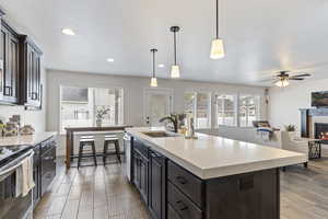 Kitchen with a ceiling fan, a sink, stainless steel appliances, light countertops, and recessed lighting