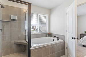 Ensuite bathroom featuring a shower stall, a garden tub, and ensuite bathroom