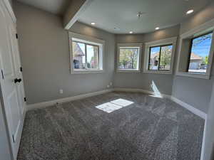 Carpeted empty room with recessed lighting, visible vents, and plenty of natural light