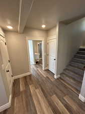 Entrance foyer with dark wood-style flooring, baseboards, recessed lighting, and stairway