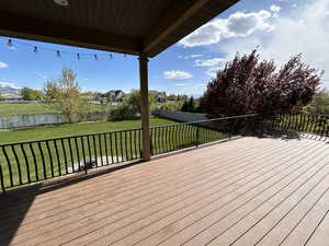 Wooden terrace featuring a lawn and a fenced backyard