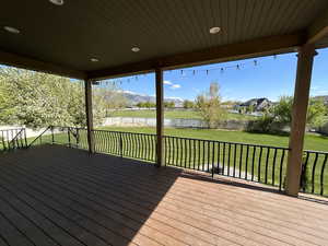 Wooden deck with a water view and a yard