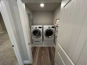 Laundry area featuring laundry area, dark wood-style flooring, baseboards, electric panel, and separate washer and dryer