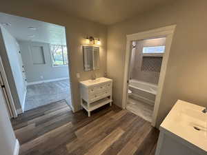 Full bath with wood finished floors, vanity, baseboards, toilet, and bathing tub / shower combination